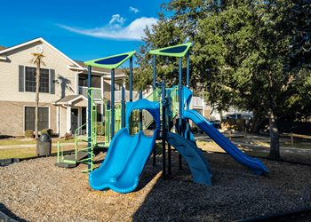 A playground with a blue slide and green play structure